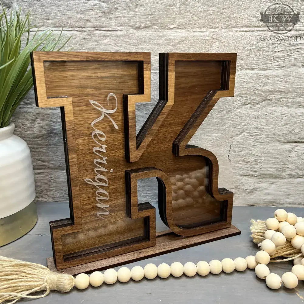 Kids wooden letter bank featuring a wooden letter K for saving coins and learning about money