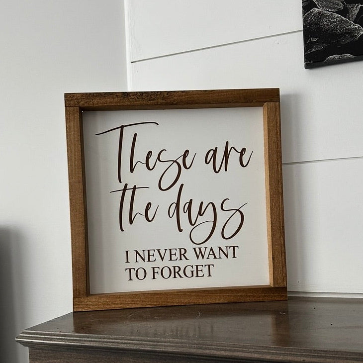 Framed sign with motivational quote on a wooden surface