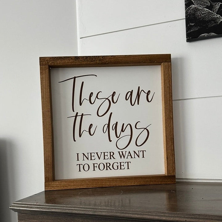 Framed sign with motivational quote on a wooden surface