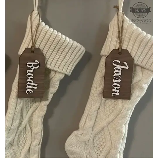Laser cut custom wooden Christmas stocking name tags on two cable-knit stockings