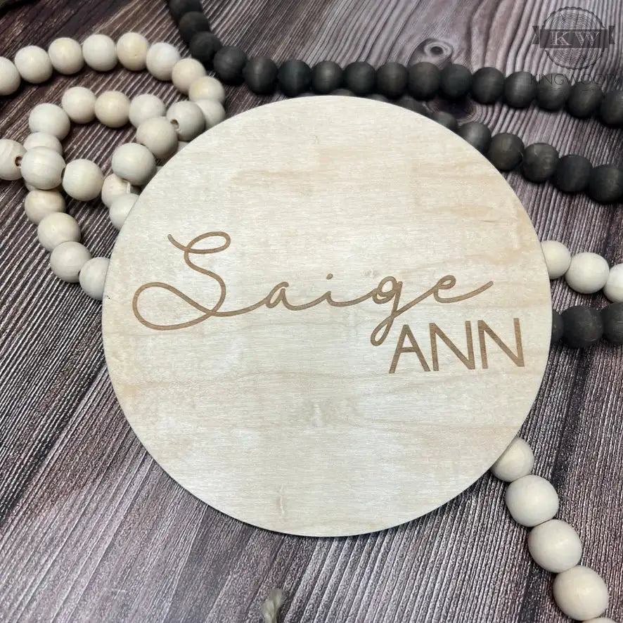 Natural birchwood baby announcement disc with unique grain and round wooden name sign