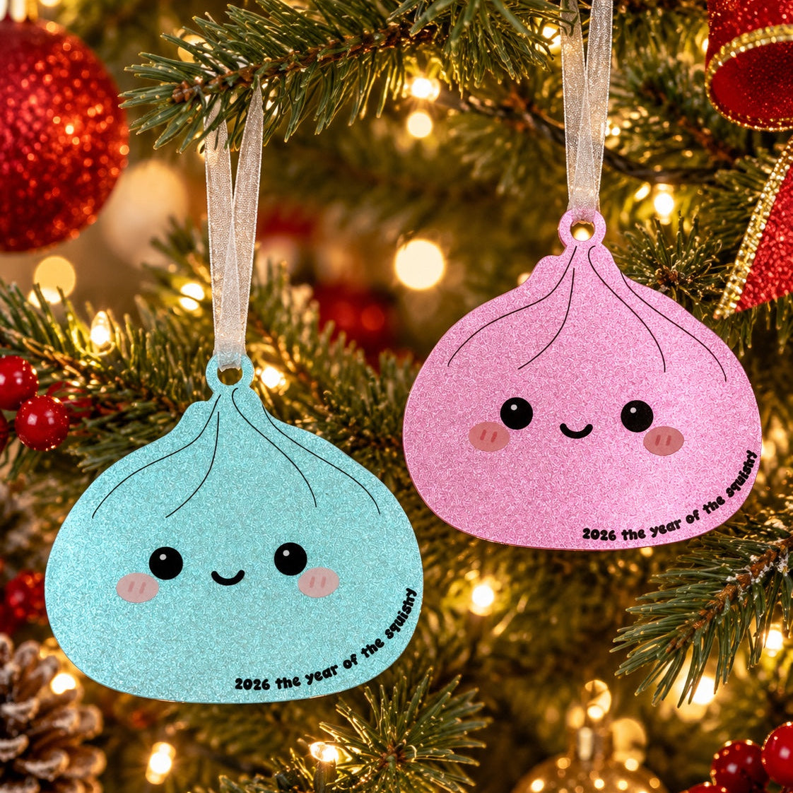 Blue and pink 2026 Year of the Squishy ornaments hanging on a Christmas tree