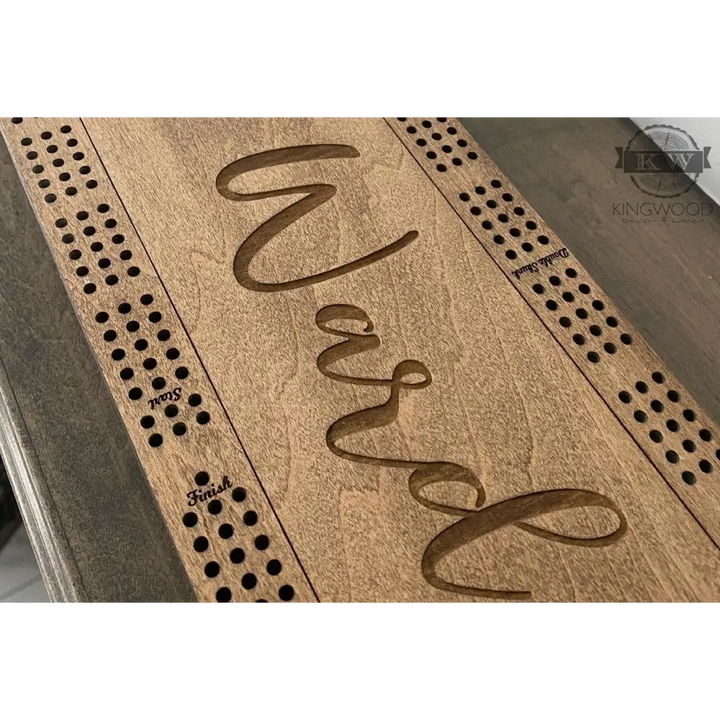 Personalized Baltic Birch cribbage board with engraved name, storage compartment, and metal pegs