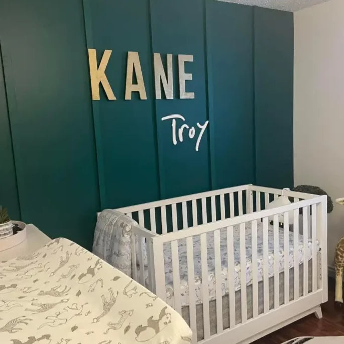White baby crib showcasing a custom laser cut name sign for home decor elegance