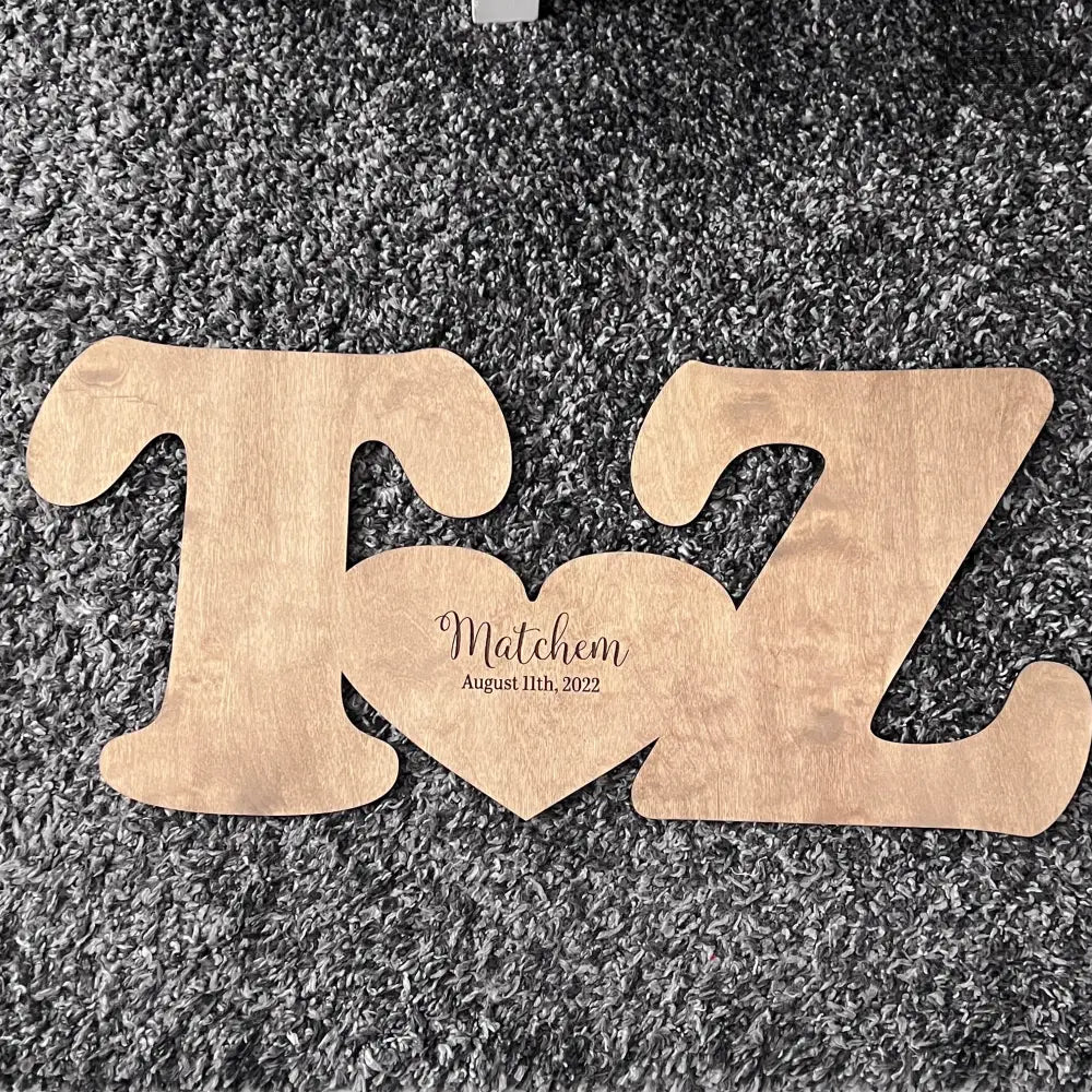 Wooden letter shaped signature sign T and Z connected by a heart for wedding guestbook